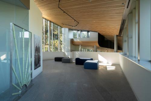 a lobby with blue chairs and a wooden ceiling at Parador Costa da Morte in Muxia