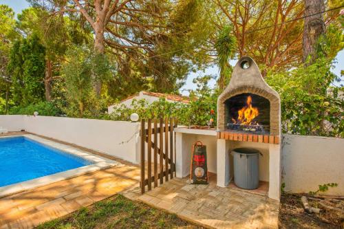 a backyard with a fireplace next to a swimming pool at Villa Namibe na Quinta da Balaia in Albufeira