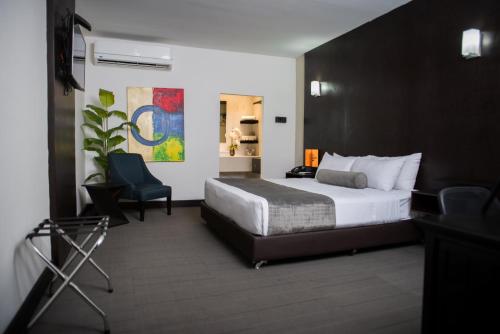 um quarto de hotel com uma cama e uma cadeira em Stay Inn Hotels em Reynosa