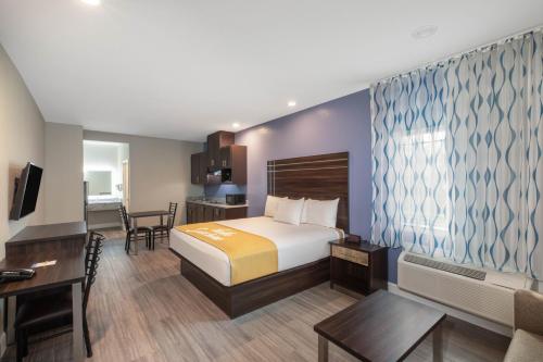 una habitación de hotel con una cama y un escritorio en Days Inn & Suites by Wyndham La Porte, en La Porte