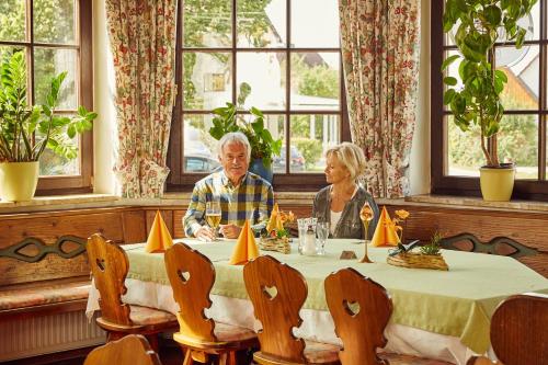 a man and a woman sitting at a table at Hotel Schloßberg in Gräfenberg