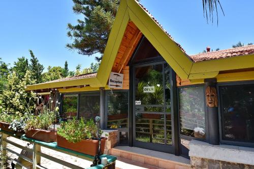 a building with a yellow roof with plants on the porch at Out of Africa Resort in Had Nes