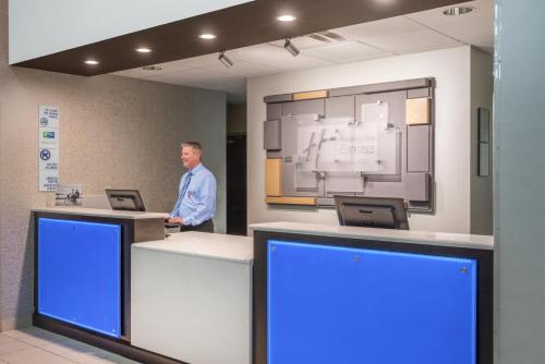 a man standing at a counter in a hospital lobby at Holiday Inn Express Hotel & Suites- Gadsden by IHG in Gadsden