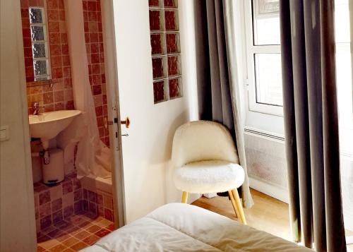 La petite salle de bains est pourvue d'une chaise et d'un lavabo. dans l'établissement Ancienne maison de maîtres, à Lourmarin