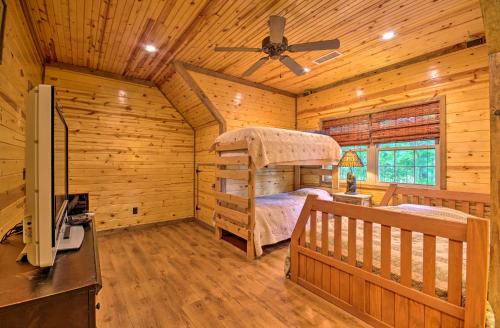 a bedroom in a log cabin with a bunk bed at Spacious Family Home with Fire Pit by Norfork Lake! in Mountain Home