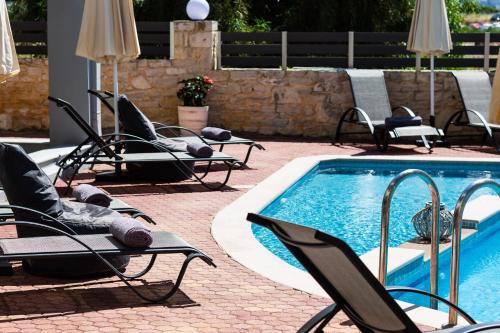 grupa krzeseł i basen w obiekcie Helena's Aparthotel , Scaleta w mieście Prínos