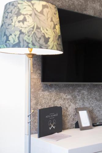 a lamp sitting on top of a desk with a tv at Boutique Hotel Aichinger in Nussdorf am Attersee