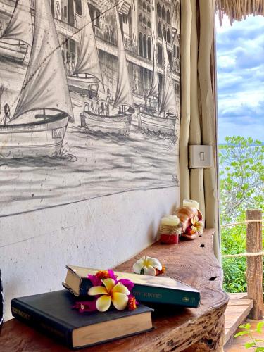 two books on a table with a drawing of boats at Rock and Sea Resort in Watamu
