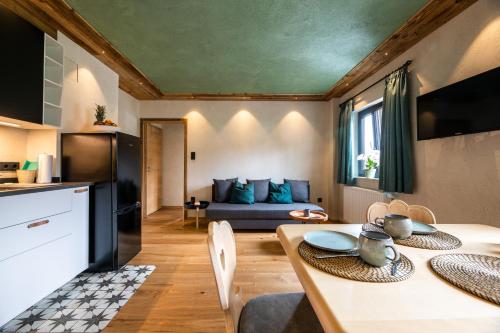 een keuken en een woonkamer met een tafel en een bank bij Gästehaus Richter in Grainau