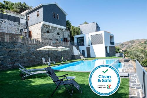 a villa with a pool and a sign that says clean and safe at Casa Foz do Corgo - private pool, gardens and river access in Peso da Régua