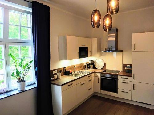 a kitchen with white cabinets and a large window at Ferienwohnungen Georgenbruch in Everswinkel