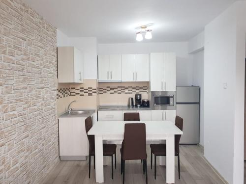 uma cozinha com uma mesa branca e cadeiras em Apartament Posada em Curtea de Argeş