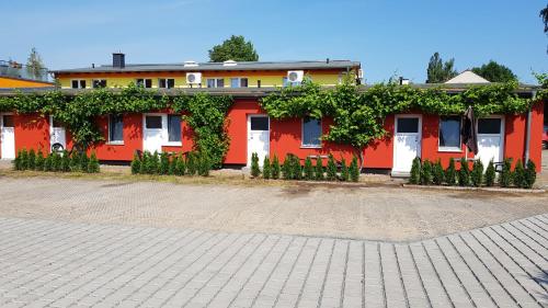 a red and white building with vines on it at Appartement Vermietung Brunner in Rostock
