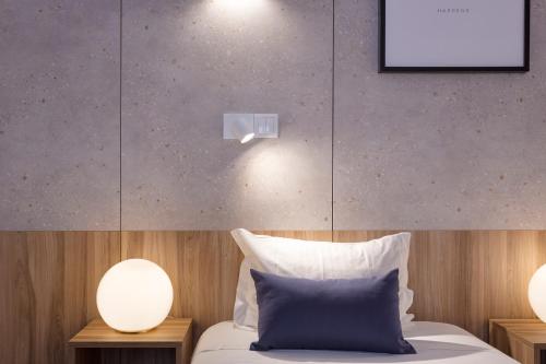 a bedroom with a bed with two lights on the wall at Hotel Made Inn in Portimão