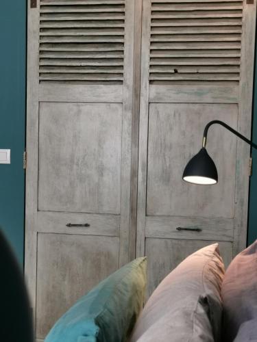 a wooden closet with a lamp next to a bed at La Cabane du Pecheur in Honfleur