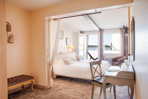 um quarto com uma cama, uma secretária e uma janela em Hotêl & Spa Du Parc Fétan em Larmor-Baden