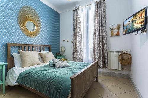 - une chambre avec un lit aux murs bleus et un miroir dans l'établissement MY CASA - DIJON, à Nice