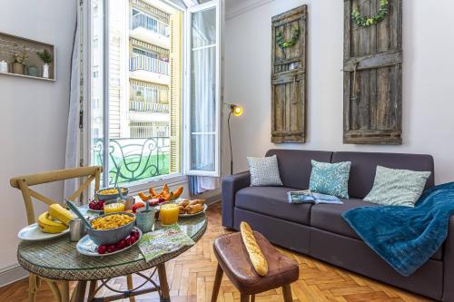 - un salon avec un canapé et une table avec de la nourriture dans l'établissement MY CASA - DIJON, à Nice