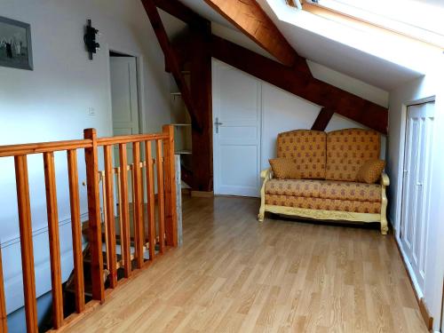 a living room with a chair and a staircase at manade Blanc - Gite la Fenière in Arles