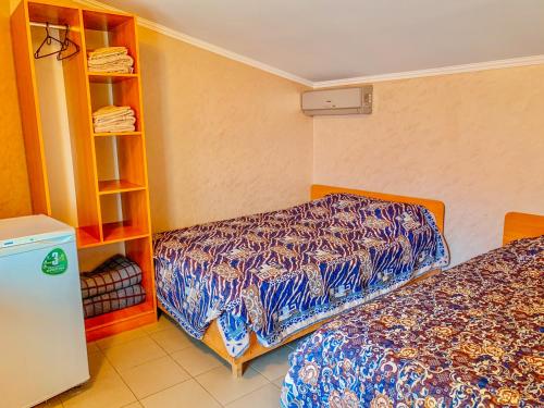 a room with two beds and a book shelf at Хутірська 48 in Sanzhiyka