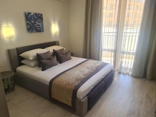 - une chambre avec un grand lit et des oreillers dans l'établissement Private Apartment in Star Dreams Complex, à Sveti Vlas