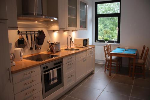 une cuisine avec des placards blancs, une table et une fenêtre dans l'établissement Ferienwohnung Eddelhoff, à Kalyves