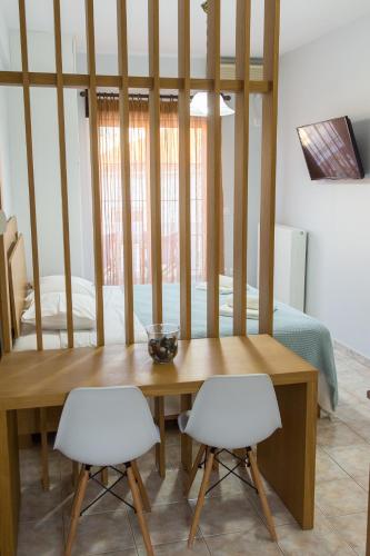 エルミオニにあるVasilis Apartmentsのダイニングルーム(テーブル、白い椅子2脚付)