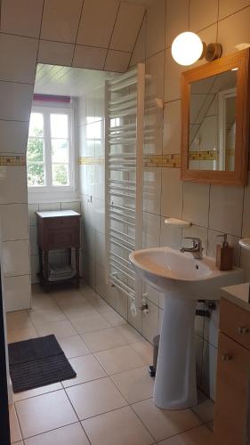 a white bathroom with a sink and a window at Maison d'hôtes Il était une fois in Pont-lʼÉvêque