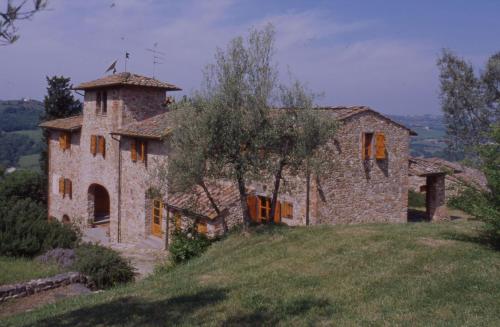 a large stone house on a hill in a field at Castello di Bibbione in San Casciano in Val di Pesa