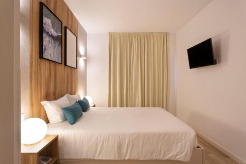 a hotel room with a bed and a television at Hotel Made Inn in Portimão