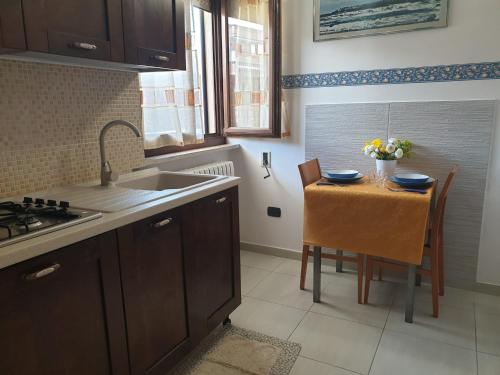 ガリポリにあるBilocale Blu - A casa di Ludovica e Martinaのキッチン(シンク、テーブル、椅子付)
