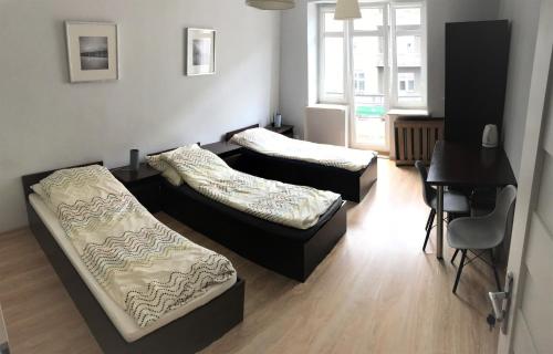 een woonkamer met 2 bedden en een piano bij SHIRE Gdynia in Gdynia