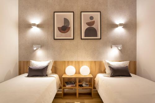 two beds sitting next to each other in a room at Hotel Made Inn in Portimão