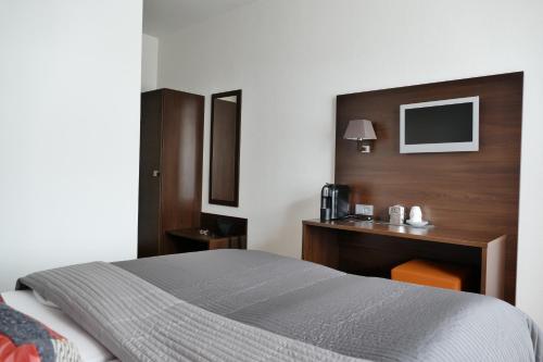 a hotel room with a bed and a desk at DAS Steeps Ihr Brauhaus und Hotel in Cologne