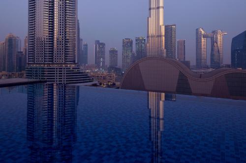 Address Dubai Mall في دبي: اطلالة على مدينة فيها جسر فوق سطح ماء