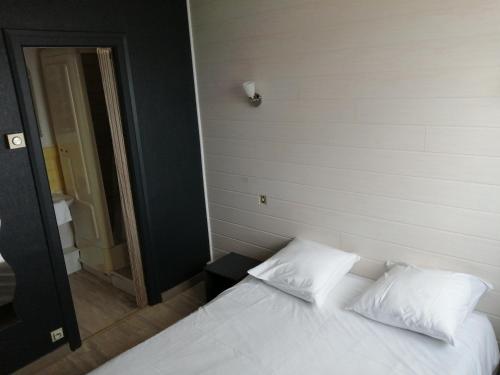 1 dormitorio con 1 cama blanca y 2 almohadas en Les Voyageurs en Vairé