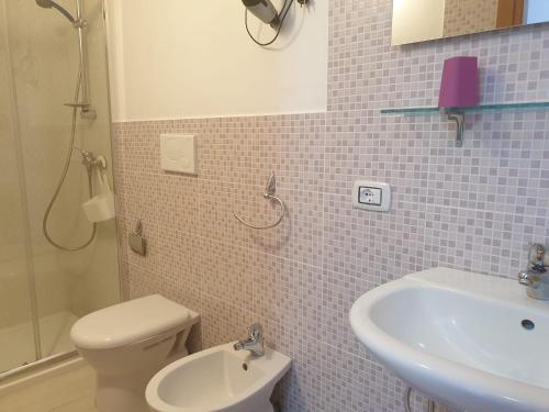 ein Badezimmer mit weißer Toilette und Waschbecken in der Unterkunft Monolocale Viola - A casa di Ludovica e Martina in Gallipoli