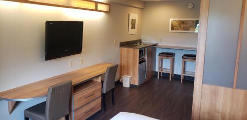 a room with a desk with a tv on the wall at York Microtel Inn & Suites by Wyndham in York