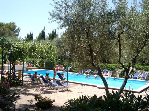 a group of people sitting around a swimming pool at Villa Matisse - Damecuta Park in Anacapri