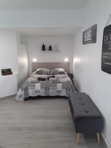 a bedroom with a bed and a bench in it at Gîte les Oliviers les HERBIERS in Les Herbiers