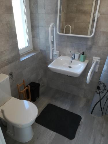 ein Badezimmer mit weißer Toilette und Waschbecken in der Unterkunft Armona in Ustka