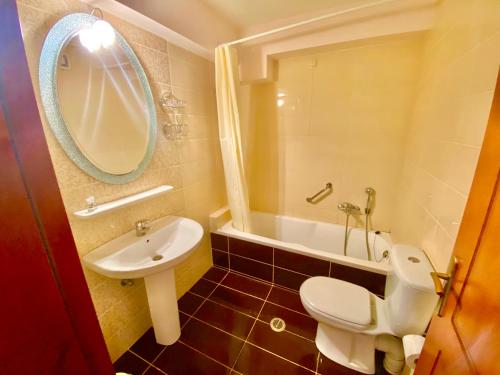 La salle de bains est pourvue de toilettes blanches et d'un lavabo. dans l'établissement Zoom Beach Hotel, à Kandia