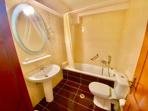 a bathroom with a white toilet and a sink at Zoom Beach Hotel in Kandia