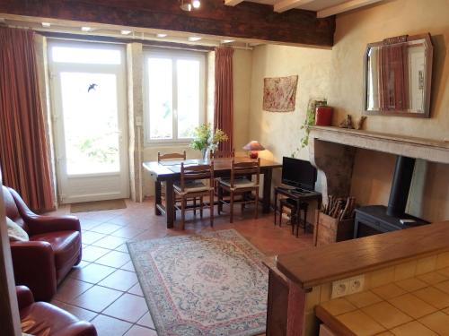 un salon avec une table et une cheminée dans l'établissement La Petite Colombe, à Sainte-Colombe