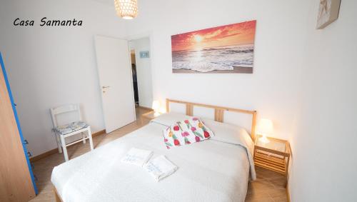 - une chambre avec un lit et une table avec une photo sur le mur dans l'établissement A & B Holiday Home, à Deiva Marina