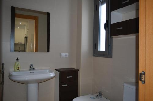 bagno con lavandino, servizi igienici e specchio di Alojamiento CAZORLA DELUXE a Cazorla