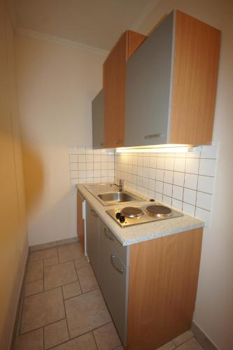 eine kleine Küche mit einer Spüle und einer Theke in der Unterkunft Der Marienhof Hotel Garni in Graz