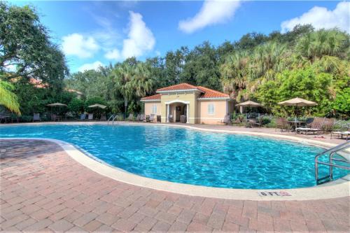 a large swimming pool with a house in the background at 4 Bedroom SunHaven Townhouse with Pool Near Disney in Kissimmee
