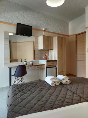 a bedroom with a large bed and a kitchen at Minos Studios in Chania Town