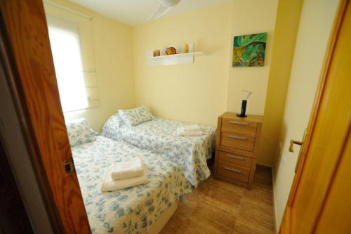 a small bedroom with two beds and a dresser at La Loma de Torrevieja in Torrevieja